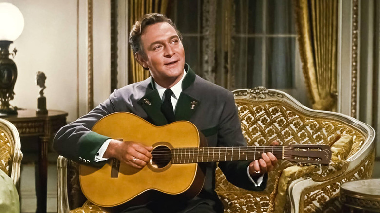 Christopher Plummer playing guitar as Captain von Trapp in a scene from The Sound of Music.