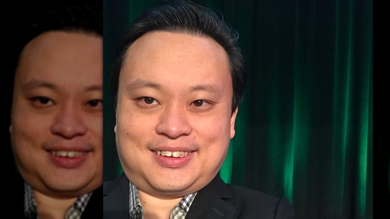 William Hung posing in front of a shimmery green curtain shortly after he got married, alone in the frame