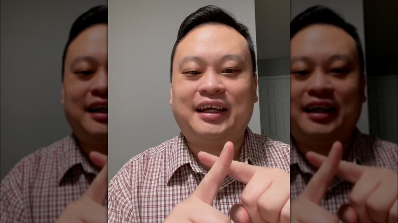 William Hung making an X with his fingers