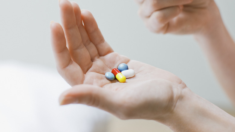 A woman with vitamins on her hand