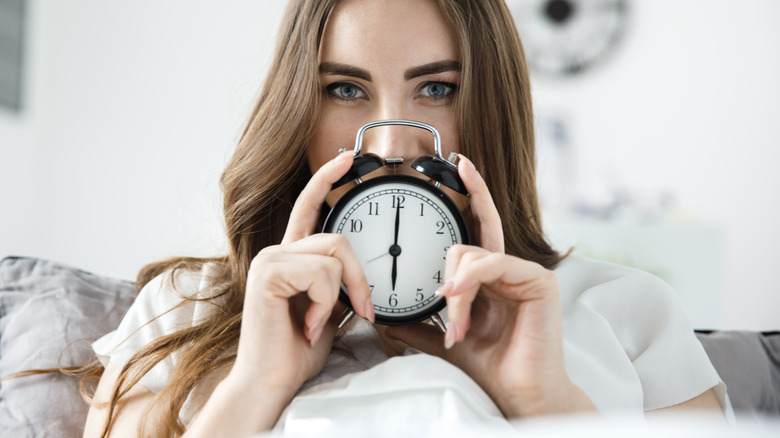 a woman holding a clock