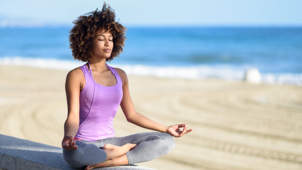 A woman doing yoga on the beach