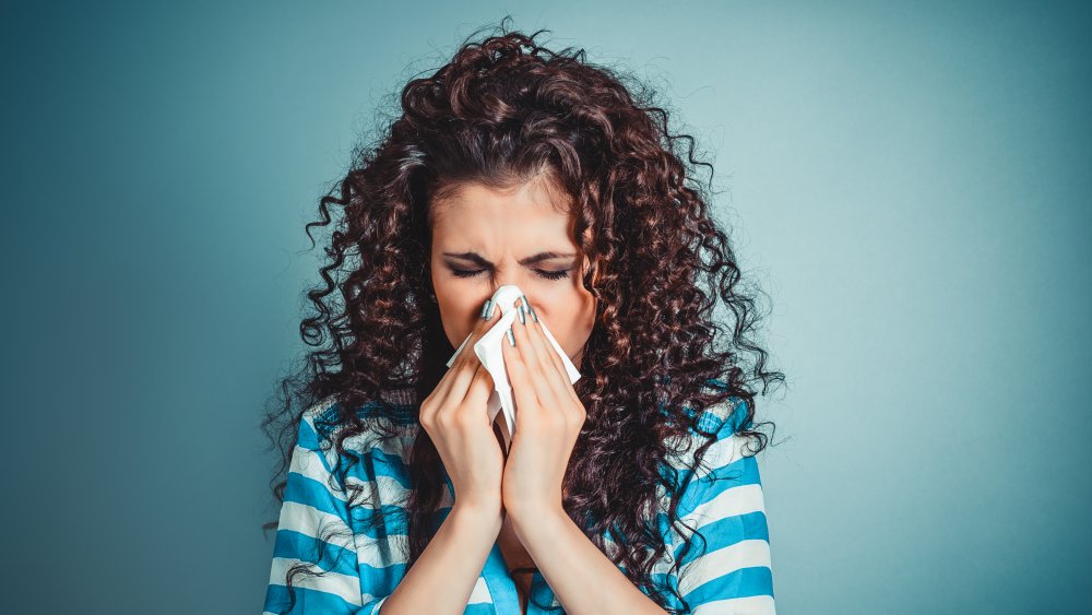 A woman blowing her nose