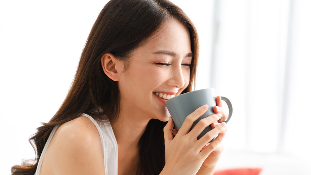 A woman holding a hot beverage