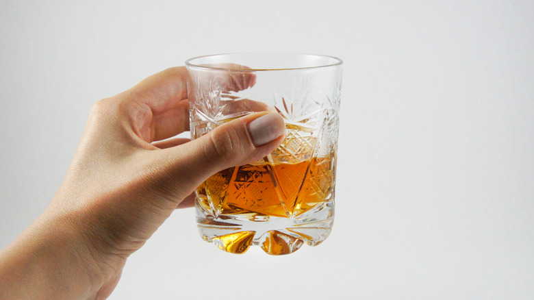 Woman holding glass of whiskey