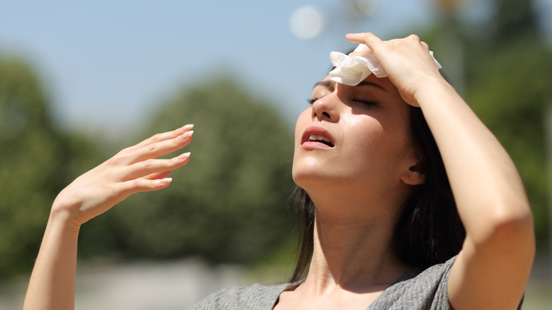 Woman drying sweat on forehead 