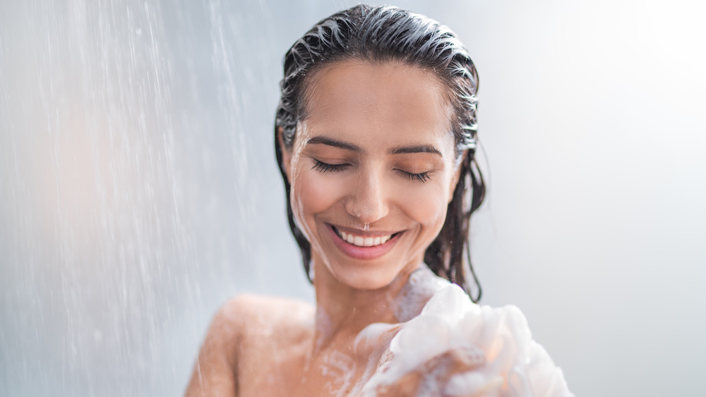 Woman washing body in shower