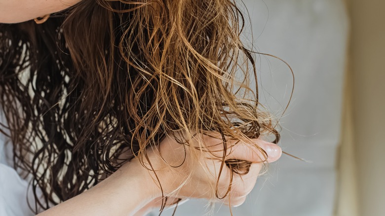Hands putting product into hair