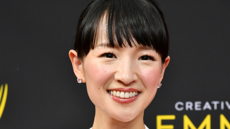 Marie Kondo with short bangs and sparky stud earrings smiles
