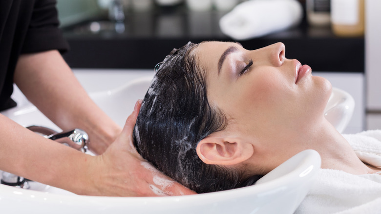 A woman getting her hair washed at a salon