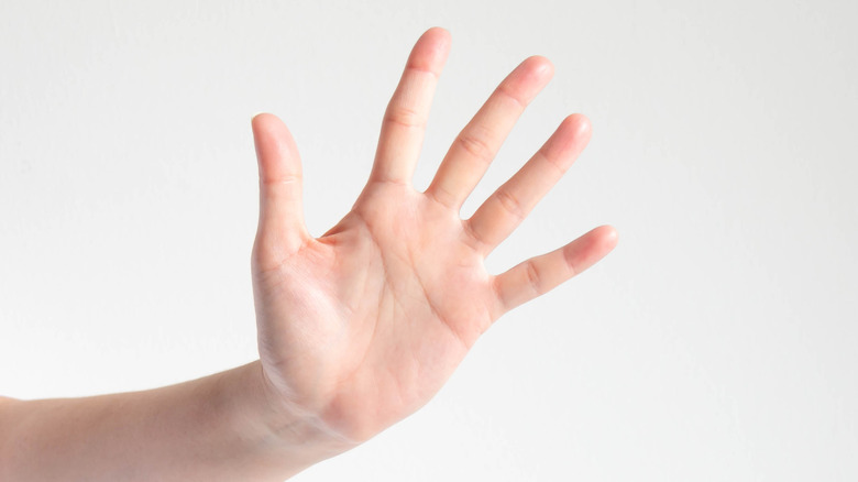 A woman holding up five fingers