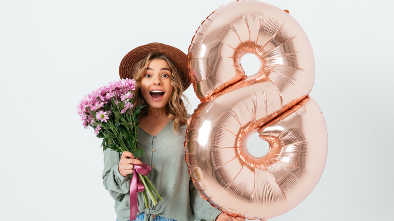 woman holding flowers and 8 balloon