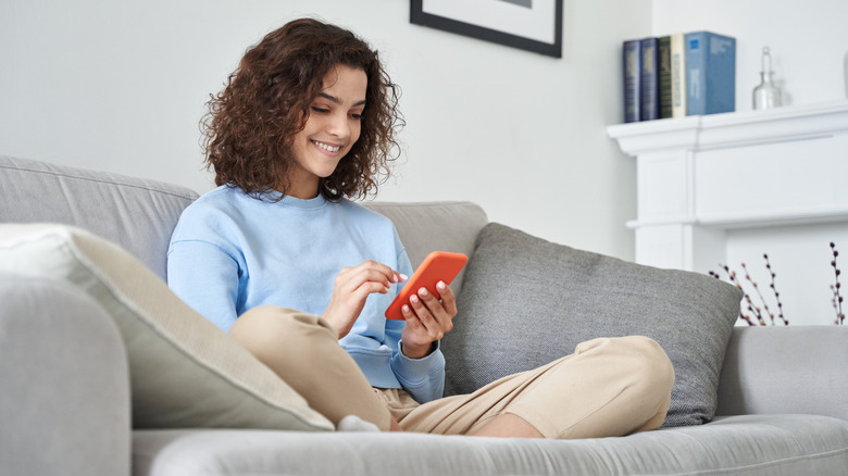 Girl holding a cell phone on a couch