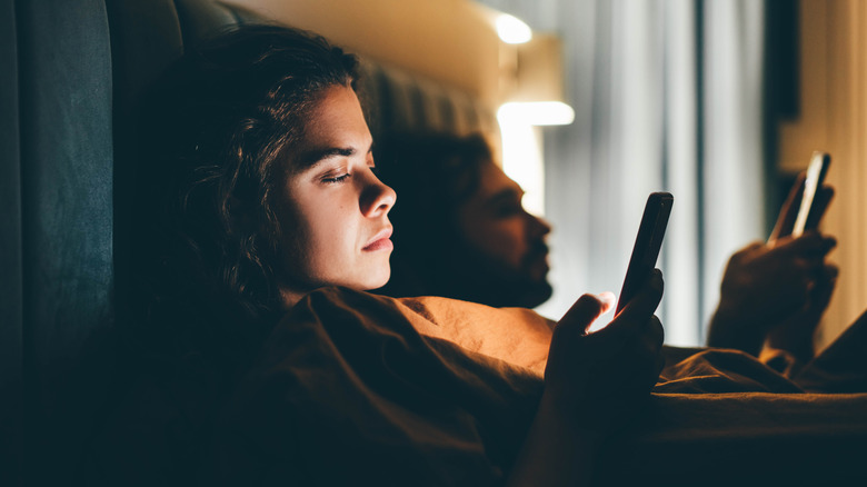 couple in bed with phones