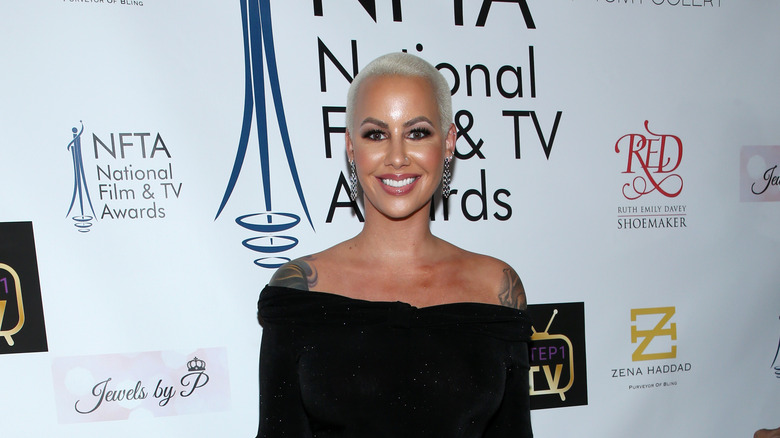 Amber Rose smiling in a strapless black gown 