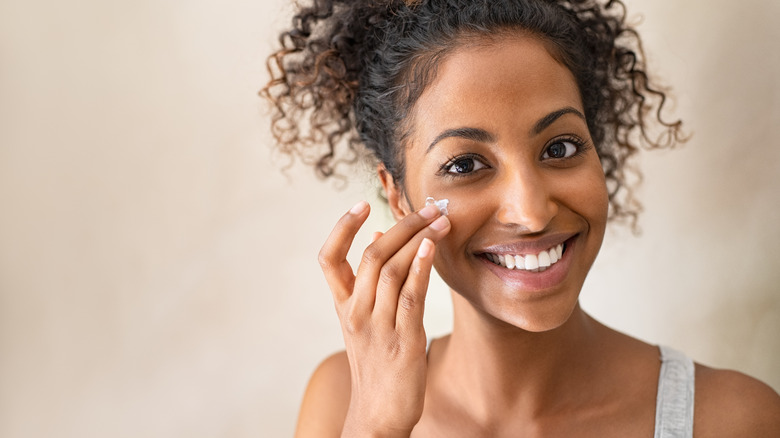 Woman applying skin cream