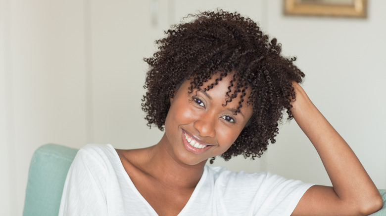 A woman with curly hair sitting on a sofa