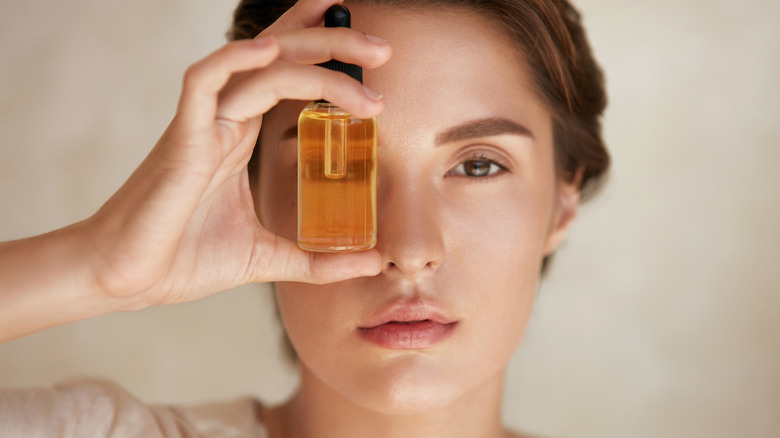 Woman holding bottle of facial oil