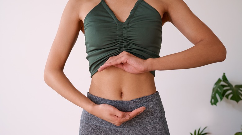 Woman with hands around stomach