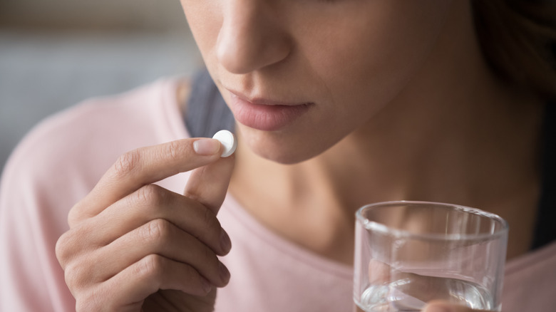Girl taking a pill looking solemn