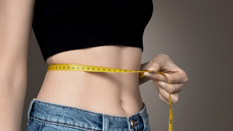 Girl measuring her waist