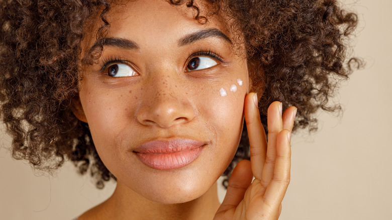 Woman applying skin care cream