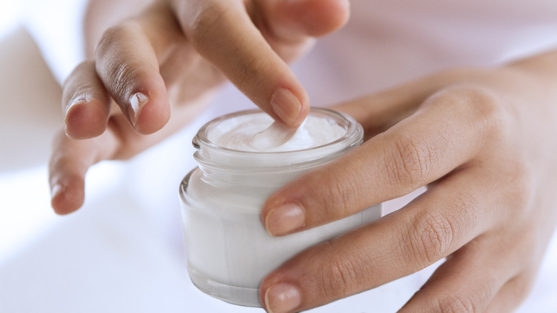 Woman applies skin care product