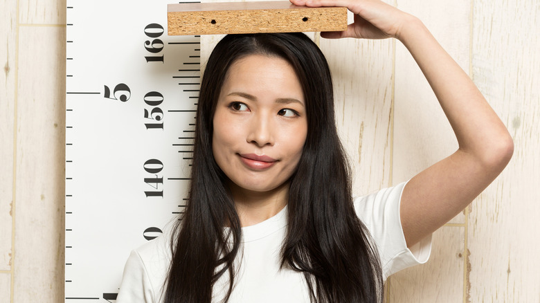 a woman measuring her height