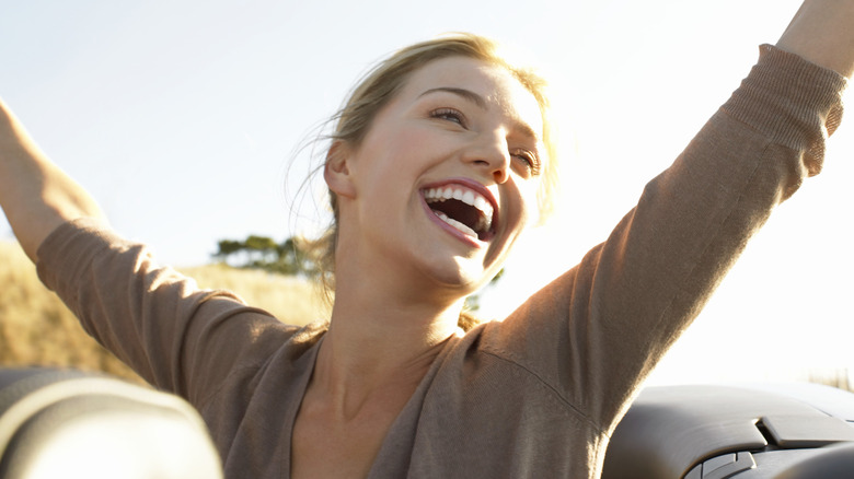 smiling woman with arms in the air