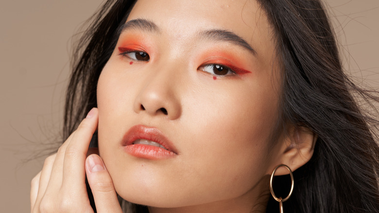 Asian woman with red-hued eyeshadow