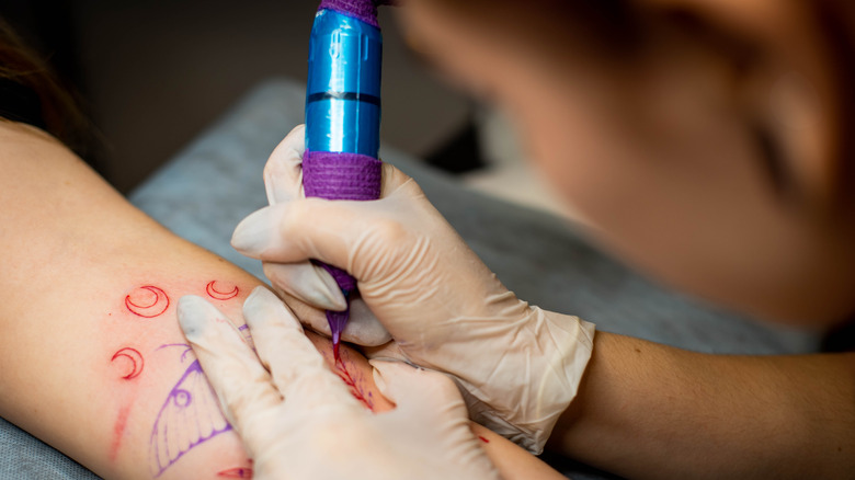 Tattoo artist drawing a design 