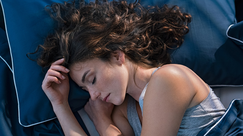 Woman sleeping on blue pillowcase