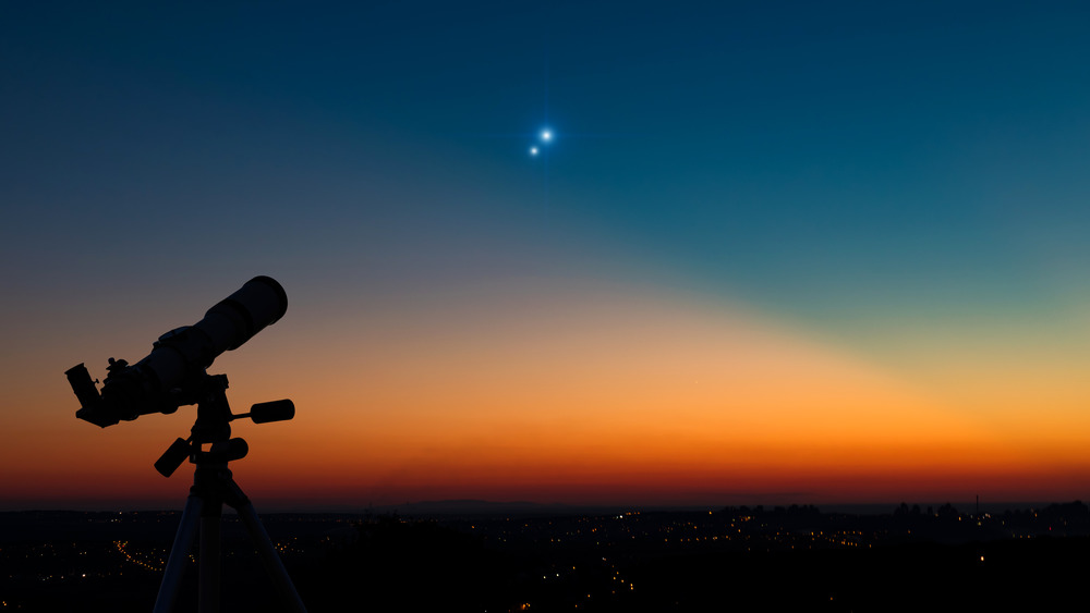 A telescope pointed at a star in the dusk sky 