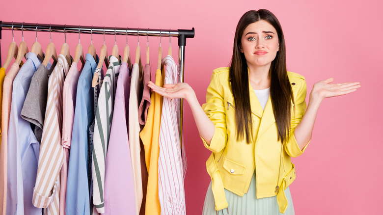 woman in yellow jacket unhappy with wardrobe selection