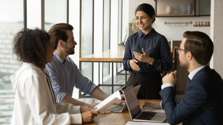 Woman leading coworkers in office