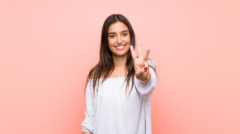 woman holding up 3 fingers