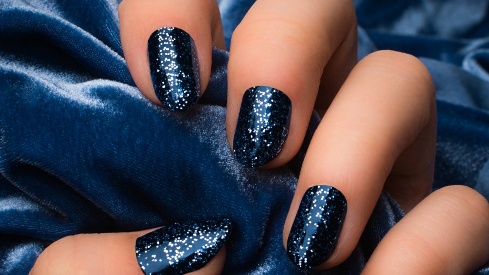 A woman's hand with dark blue nail polish