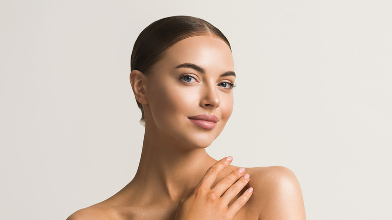 woman touching collarbone