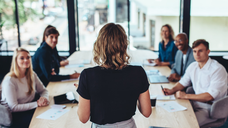 Female CEO stands up and talks to her employees