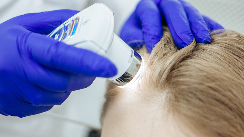 Dermatologist examining a woman's head