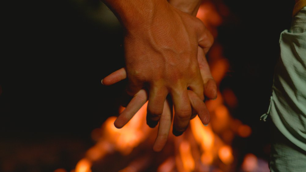 Couple holding hands while interlocking fingers