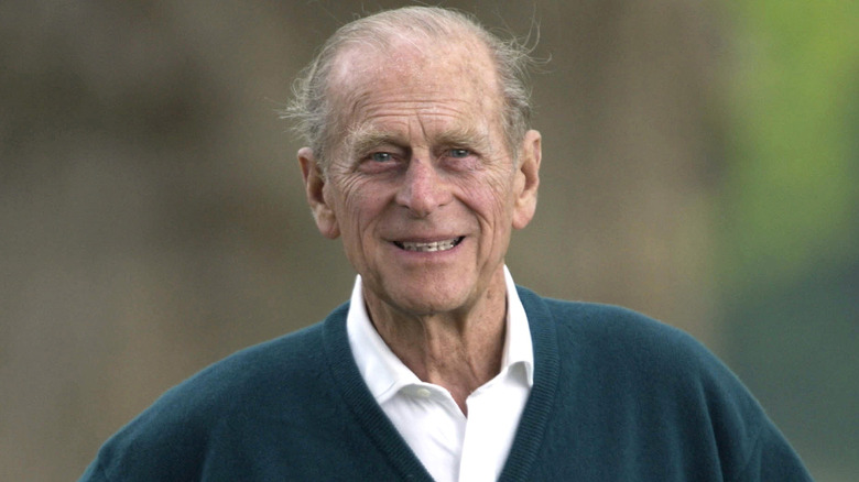 Prince Philip smiling in a green sweater
