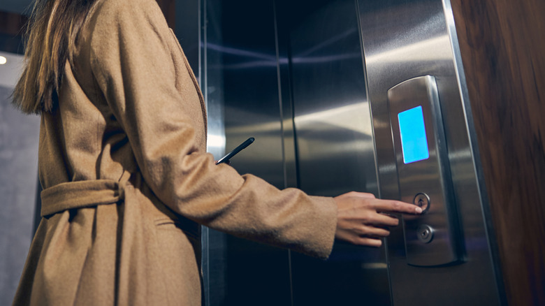 Woman pressing elevator button