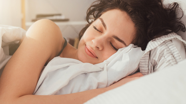 Woman sleeping in white bed