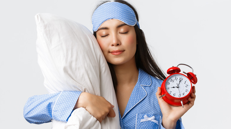 Woman sleeping and dreaming with alarm clock