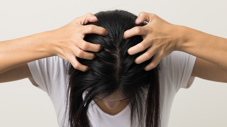 Young woman itching head