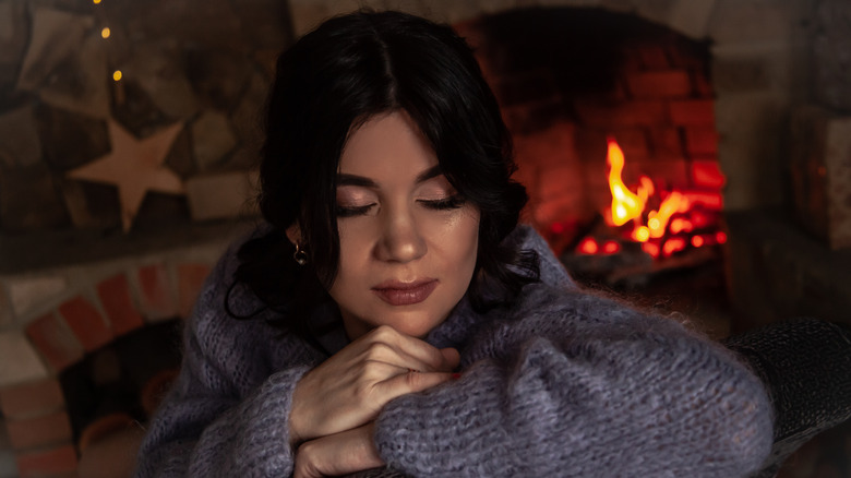 Woman sleeping in front of fire