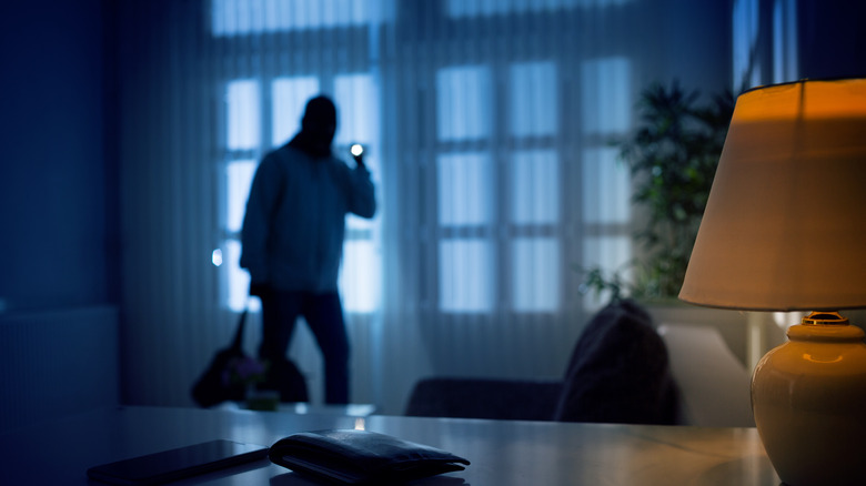 Intruder with a flashlight in a living room 