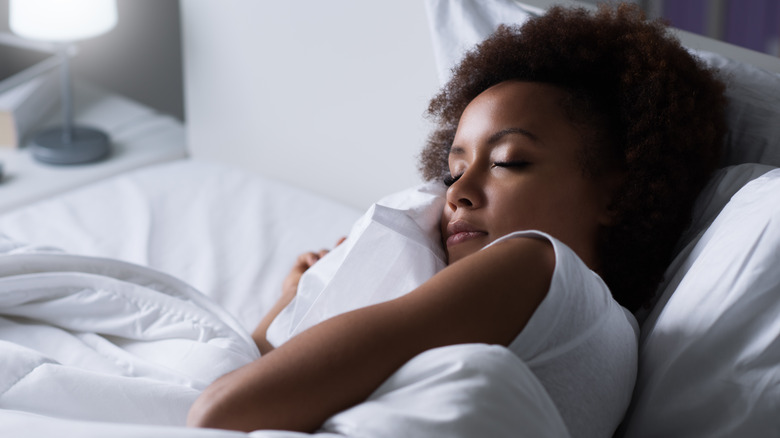 Woman sleeping against white linen