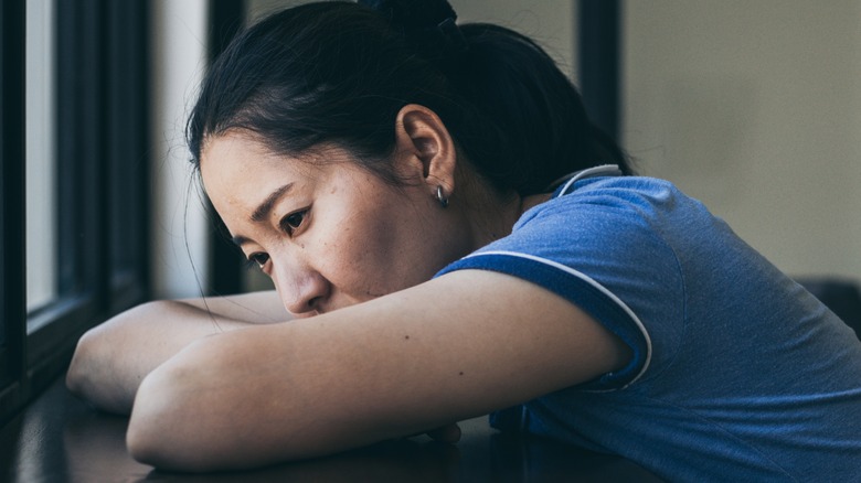 sad woman resting her head on her arms